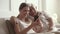 Happy family senior retired father embracing adult daughter using smartphone