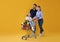 Happy family with shopping cart full of groceries on yellow background