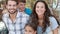 Happy family in shopping mall looking at camera