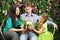 Happy family sit on white bench and hold flowers