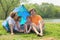 Happy family sitting in blue tent