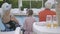 Happy family sitting on the edge of the pool, back view. Grandmother, grandfather, and grandchild relaxing at the water