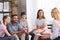 happy family sitting on therapy session by female counselor writing in clipboard