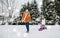 Happy family with sled walking in winter outdoors