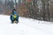 Happy family with sled in winter having fun together. Child sledding.Happy mother and her son enjoying sleigh ride. Family driving