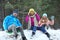 Happy family sledding in forest