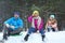 Happy family sledding in forest