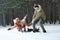 Happy family sledding in forest