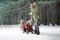 Happy family sledding in forest