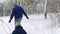 Happy family sledding on snowy winter day. Father and mother pull sled ropes with son on snowfall. Boy sledge outdoors