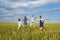 Happy family smiling running on the field in nature