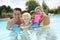Happy family spending good time in swimming pool
