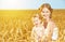 Happy family in summer nature. Mother and baby daughter in the wheat field