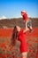 Happy family summer vacation. Mother playing with son in poppies