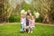 Happy family in sunny summer park having fun together on grass, leisure lifestyle of parents with children