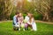 Happy family in sunny summer park having fun together on grass, leisure lifestyle of parents with children