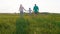 Happy family at sunset walking down the field and enjoy the moment together young parents and their child together