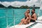 A happy family in swimsuits sits on a catamaran in the Indian ocean. portrait of a family on a yacht in the coral reef of the