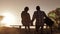 Happy family teamwork sitting on a bench silhouette sunset in the park and nature. dad and daughter relax in the park