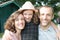 Happy family of three having fun together outdoors little daughter with hat hug mother father