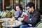 Happy family of three in Parisian outdoor cafe