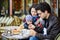 Happy family of three in Parisian outdoor cafe