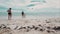 Happy family of three playing a ball on the beach