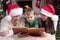 Happy family of three reading book together on Christmas evening