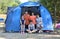 Happy family with three smiling children and tent in summer camp