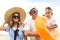 Happy family of three wearing sunglasse and hats at the sand beach