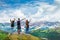 Happy family on top of beautiful mountain holding raised hands .