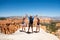 Happy family on top of beautiful mountain holding raised hands.