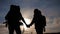 Happy family tourists walking holding hand silhouette at sunset . hikers teamwork travel concept. man and woman couple