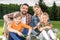 Happy family with two children holding badminton racquets and smiling