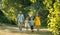 Happy family with two children holding hands during recreational walk in park