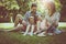 Happy family with two children in meadow using laptop and digita