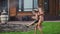 Happy family with two kids playing with garden hose pouring water on grass