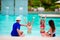 Happy family with two kids in swimming pool.