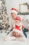 Happy family under Christmas tree. baby boy in Santa Claus hat with gifts under Christmas tree with many gift boxes presents