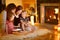 Happy family using a tablet pc by a fireplace
