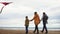 Happy family walking along the shore. Man, woman, little boy and girl playing