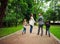 Happy family walking holding hands in green city park