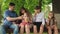 Happy family walking in the park. children and parents. Children with parents are sitting in park on bench eating ice