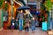 Happy family walking under the rain on colorful street