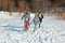 Happy family walks in winter, having fun and playing with snow outdoors on holiday weekend