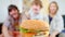Happy family wants to eat a delicious hamburger. they laugh and drawn to him
