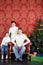 Happy family in white sweaters and jeans near Christmas tree