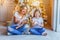 Happy family woman mother and little girl relax playing sparkler near Christmas tree on Christmas eve at home