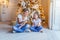 Happy family woman mother and little girl relax playing sparkler near Christmas tree on Christmas eve at home