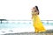 Happy family in a yellow dress. Mother and child are walking on the beach